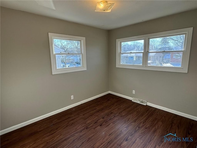 unfurnished room with dark hardwood / wood-style flooring