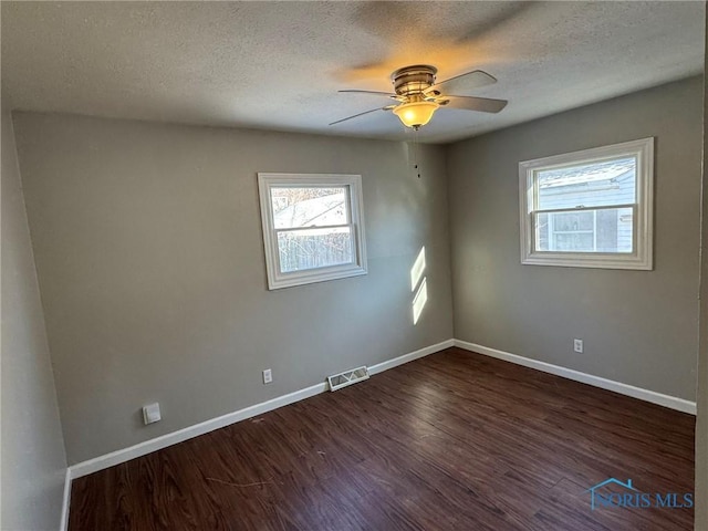 unfurnished room with ceiling fan, dark hardwood / wood-style flooring, and a textured ceiling