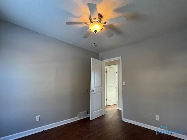 spare room featuring ceiling fan and dark hardwood / wood-style floors