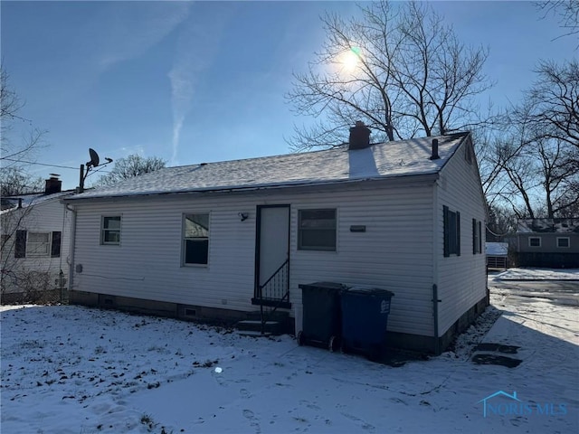 view of snow covered rear of property