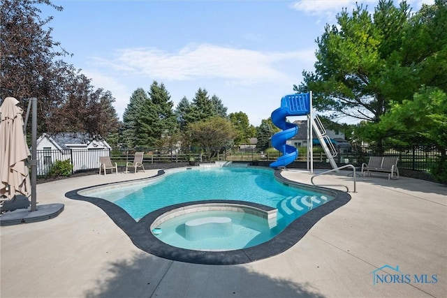 view of pool with an in ground hot tub, a patio, a playground, and a water slide