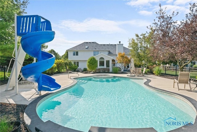 view of pool featuring a patio, a water slide, and a jacuzzi