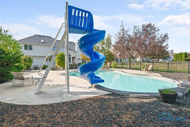 view of swimming pool with a water slide and a patio area