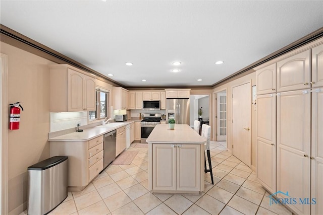 kitchen with stainless steel appliances, a kitchen breakfast bar, a center island, and light tile patterned floors