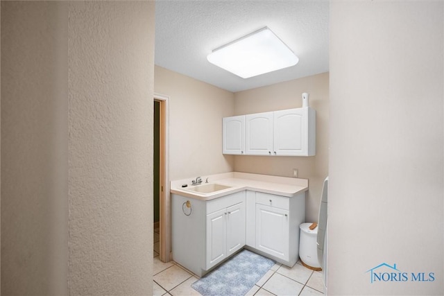 washroom featuring sink and light tile patterned flooring