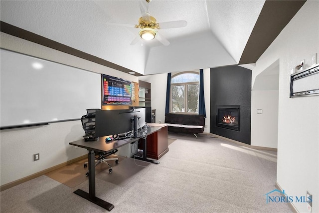 carpeted home office featuring ceiling fan, a fireplace, vaulted ceiling, and a textured ceiling