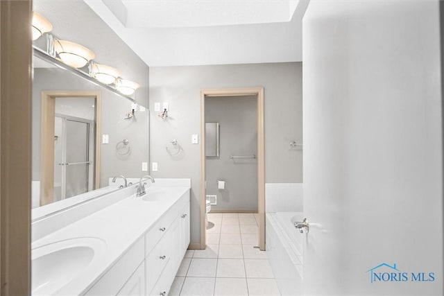 bathroom with vanity, tiled bath, tile patterned floors, and toilet