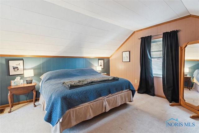 carpeted bedroom featuring vaulted ceiling and wooden walls