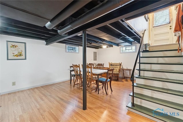 basement with light hardwood / wood-style floors and electric panel