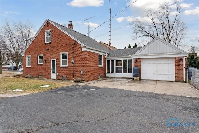 view of front of property with a garage and a sunroom