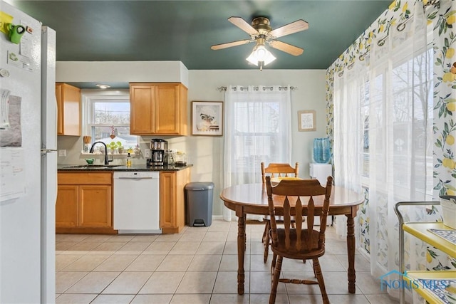 kitchen with plenty of natural light, sink, light tile patterned floors, and white appliances