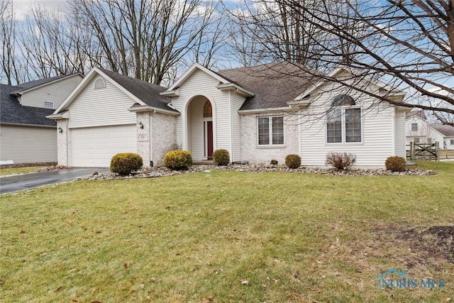 ranch-style home with a garage and a front lawn