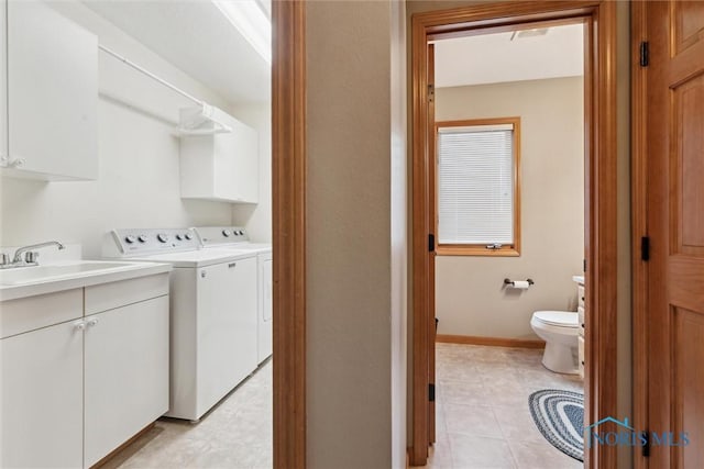 washroom with separate washer and dryer, sink, and cabinets