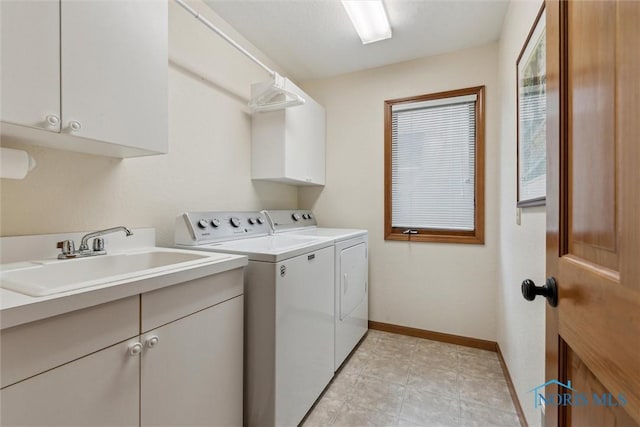 clothes washing area with washer and dryer, sink, and cabinets