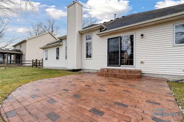 rear view of house featuring a lawn and a patio area