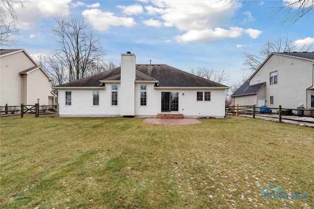 back of property with a yard and a patio area