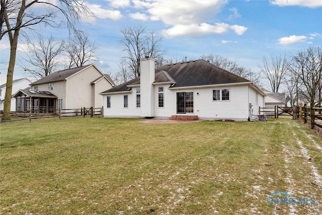 rear view of house featuring a lawn