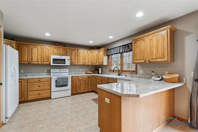 kitchen featuring white appliances, kitchen peninsula, and sink