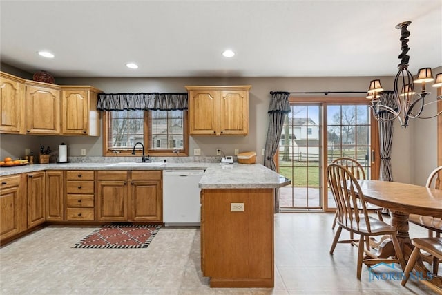 kitchen with dishwasher, sink, hanging light fixtures, and a notable chandelier