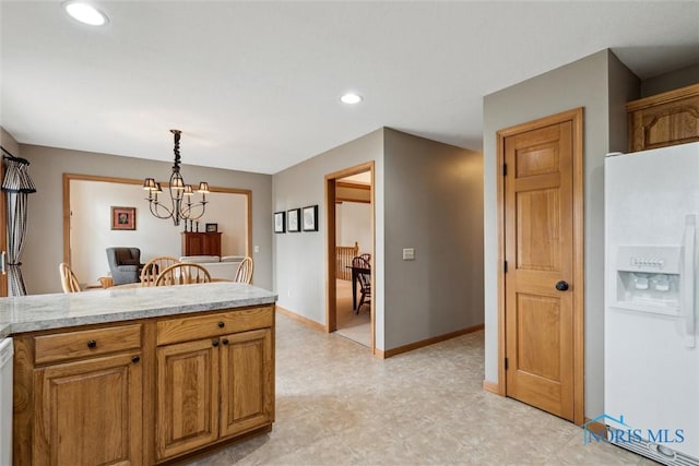 kitchen featuring an inviting chandelier, white appliances, and hanging light fixtures