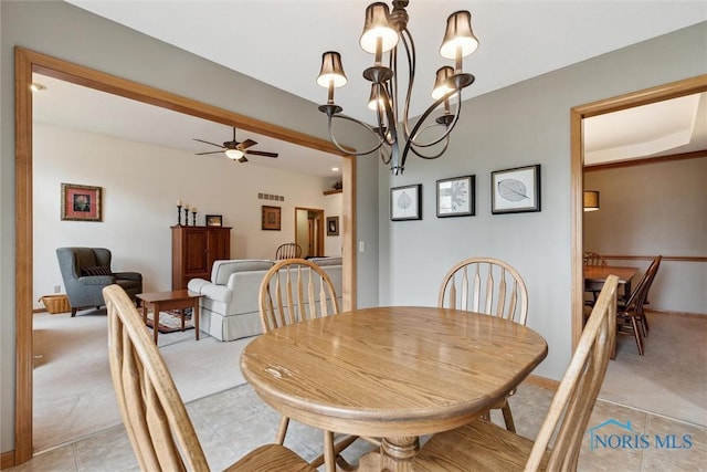 dining room featuring light carpet and ceiling fan with notable chandelier