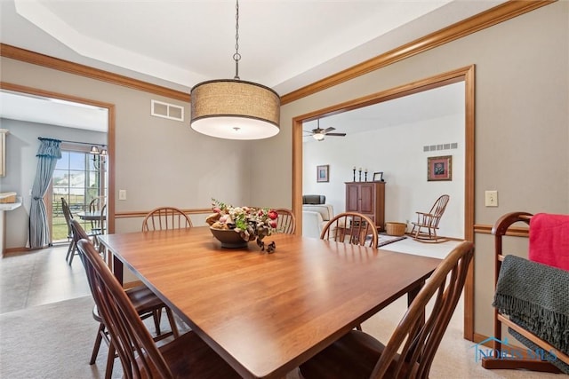 dining area with crown molding, light colored carpet, and ceiling fan