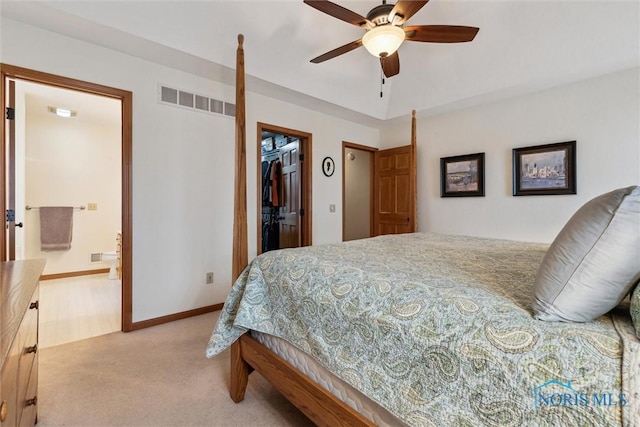 carpeted bedroom featuring ceiling fan, a walk in closet, ensuite bathroom, and a closet