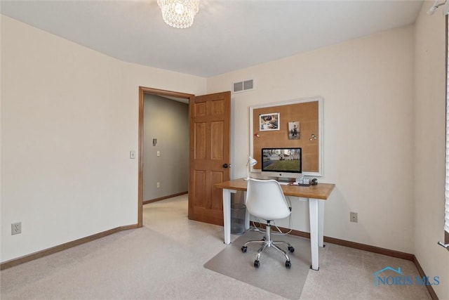 office area with an inviting chandelier and light colored carpet