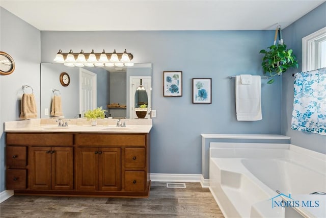 bathroom with vanity, a bathtub, and wood-type flooring