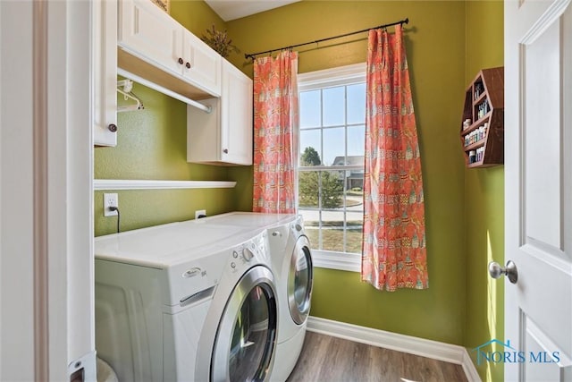 washroom with cabinets, washer and clothes dryer, and light hardwood / wood-style flooring