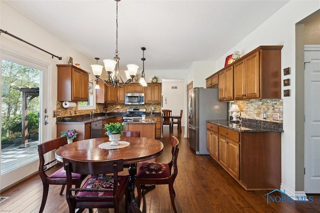 dining space featuring dark hardwood / wood-style floors, sink, and an inviting chandelier