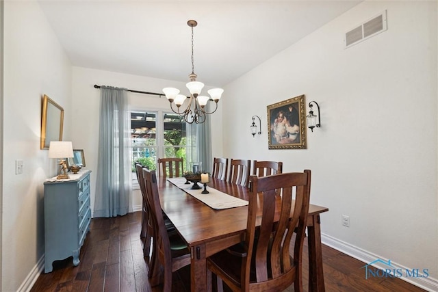 dining area with dark hardwood / wood-style flooring and a chandelier