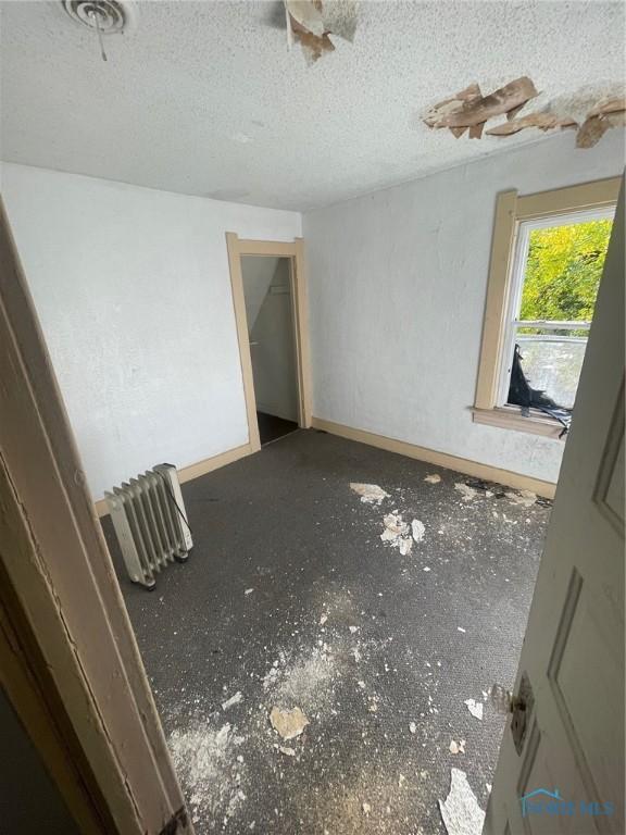 unfurnished room with a textured ceiling