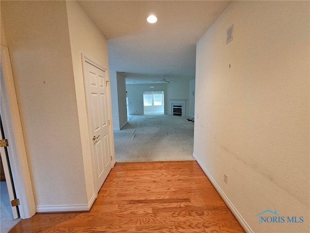 hallway featuring light colored carpet