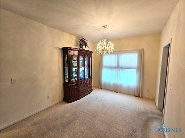 unfurnished dining area featuring light colored carpet and a notable chandelier