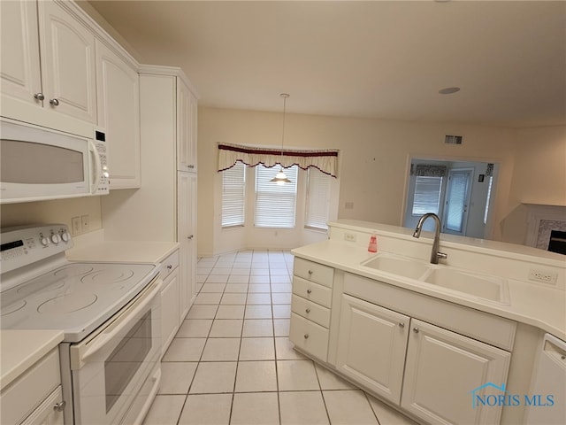 kitchen featuring sink, white appliances, light tile patterned floors, white cabinets, and decorative light fixtures