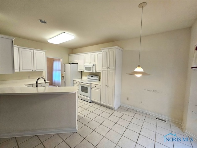 kitchen with hanging light fixtures, light tile patterned floors, kitchen peninsula, white appliances, and white cabinets