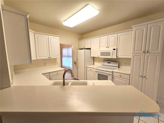 kitchen with white cabinetry, sink, white appliances, and kitchen peninsula