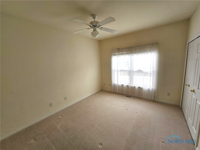 spare room with light colored carpet and ceiling fan