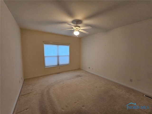 empty room featuring ceiling fan and light carpet