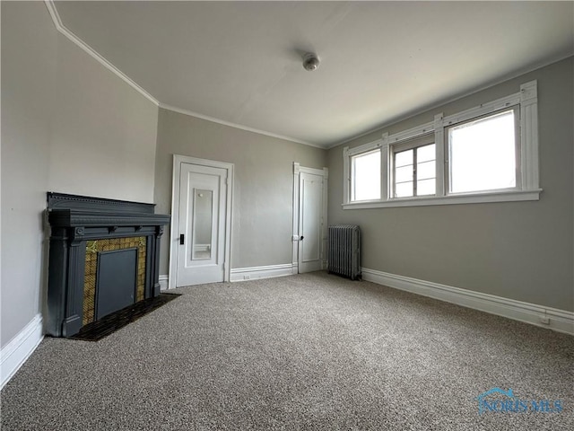 unfurnished living room featuring radiator, crown molding, and carpet