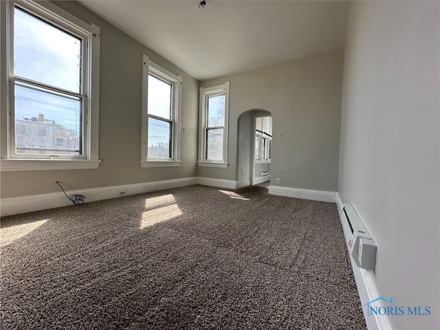 carpeted spare room with a baseboard radiator