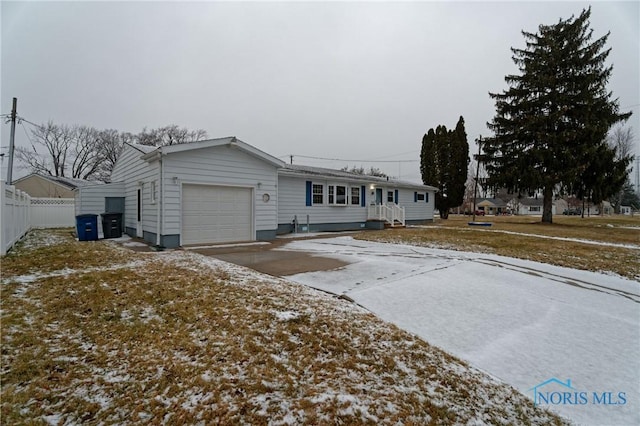 ranch-style house featuring a garage and a yard