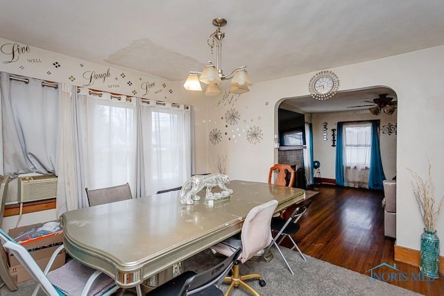 dining room featuring a tiled fireplace, cooling unit, and dark hardwood / wood-style flooring