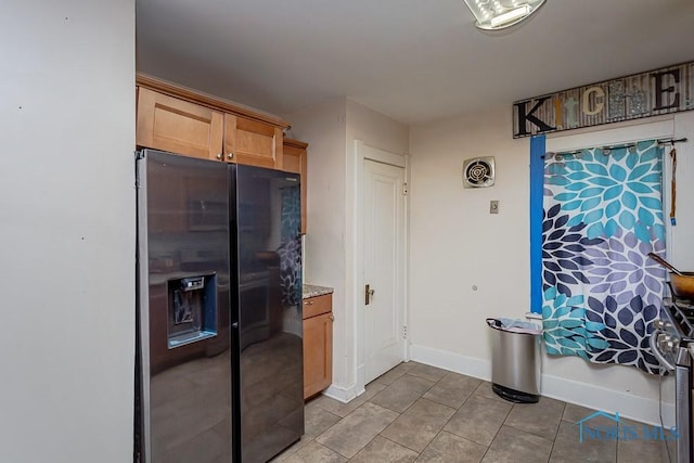 kitchen featuring stainless steel refrigerator with ice dispenser and light tile patterned floors