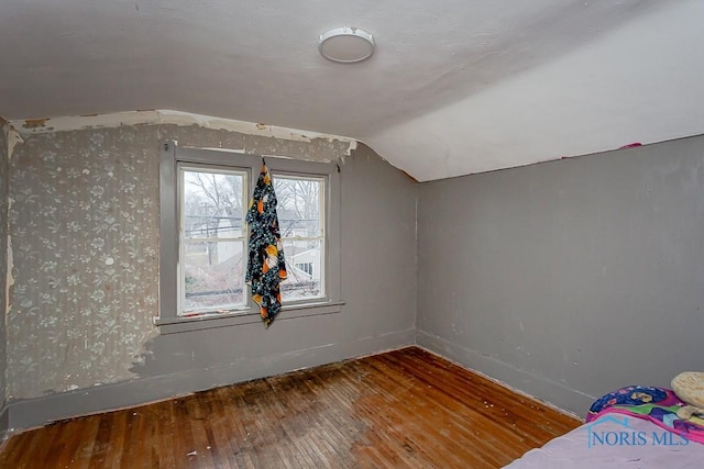 additional living space featuring vaulted ceiling and hardwood / wood-style floors