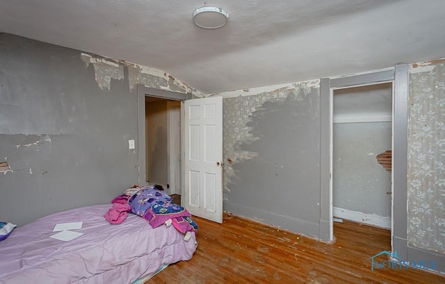 bedroom with lofted ceiling and hardwood / wood-style flooring