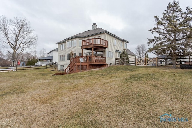 rear view of property with a deck and a lawn