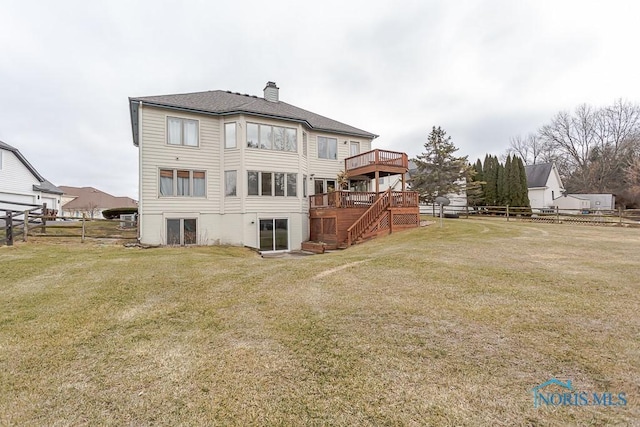 back of house featuring a wooden deck and a yard