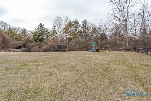 view of yard with a playground and a trampoline